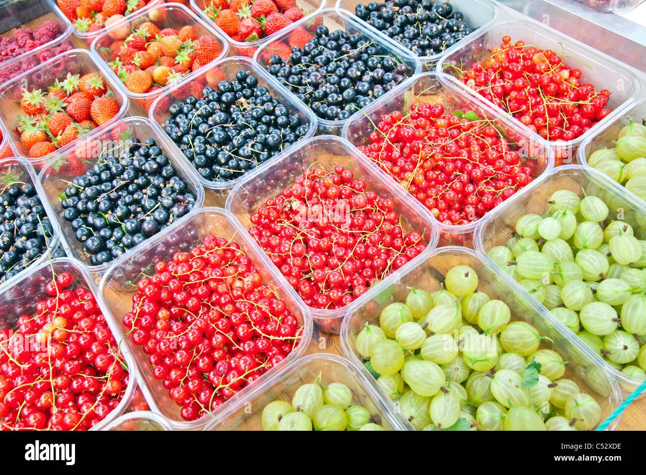 A selection of colourful fresh British soft fruit for sale on a greengrocer's barrow in Somerset England, UK Stock Photo