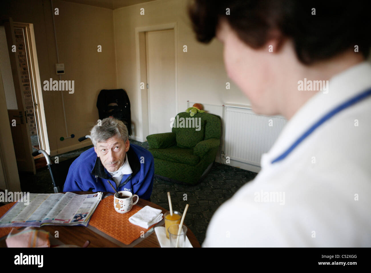 A 'Carewatch' worker caring for a customer in their own home. Stock Photo