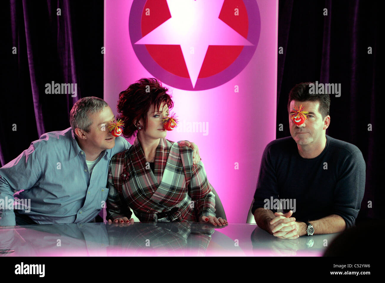 X-factor judges, Sharon Osborne and Louis Walsh share a laugh with Simon Cowell for comic relief. Stock Photo