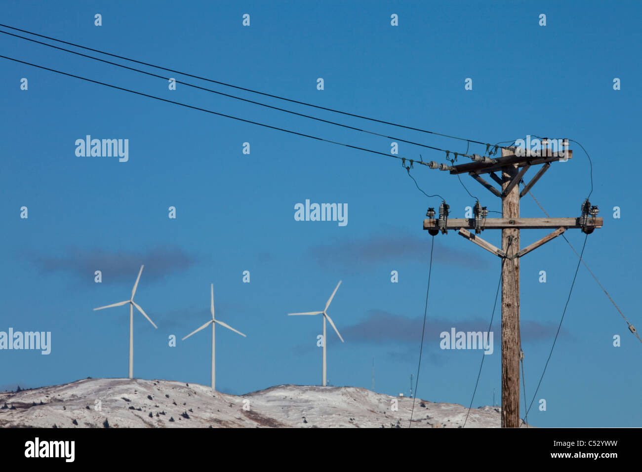 Pillar Mountain Wind Project wind turbines, Kodiak Island with electric poles and lines in the foreground, Alaska Stock Photo