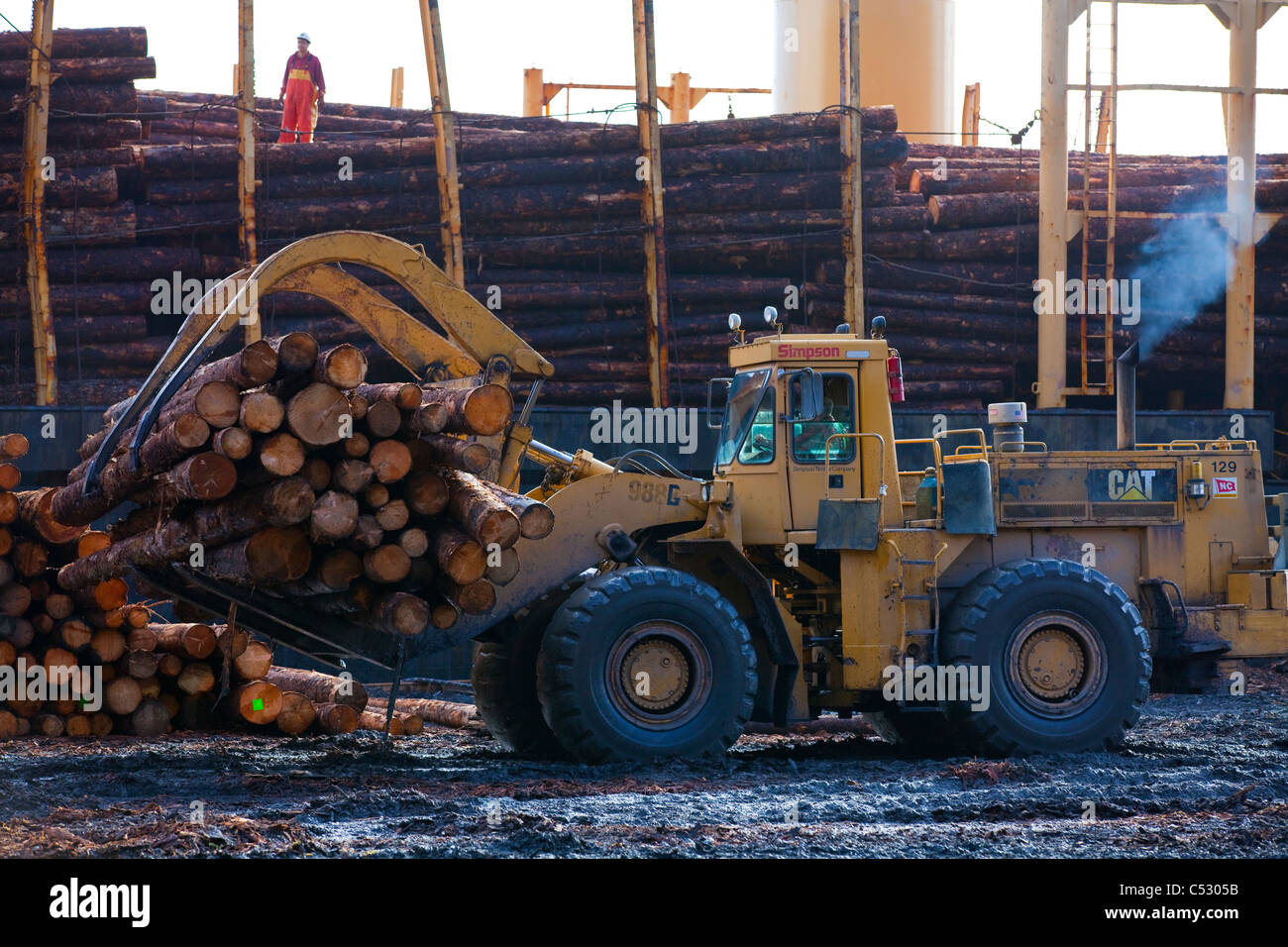 Log ship being loaded with Sitka Spruce from Chiniak and Sequel Point at LASH dock in Women's Bay, Kodiak Island, Alaska Stock Photo