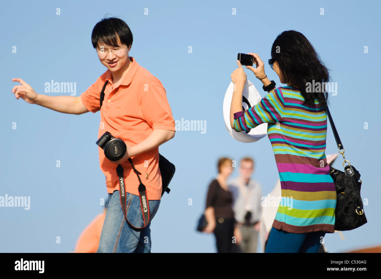 Asian international tourists or students taking photographs of each other Stock Photo