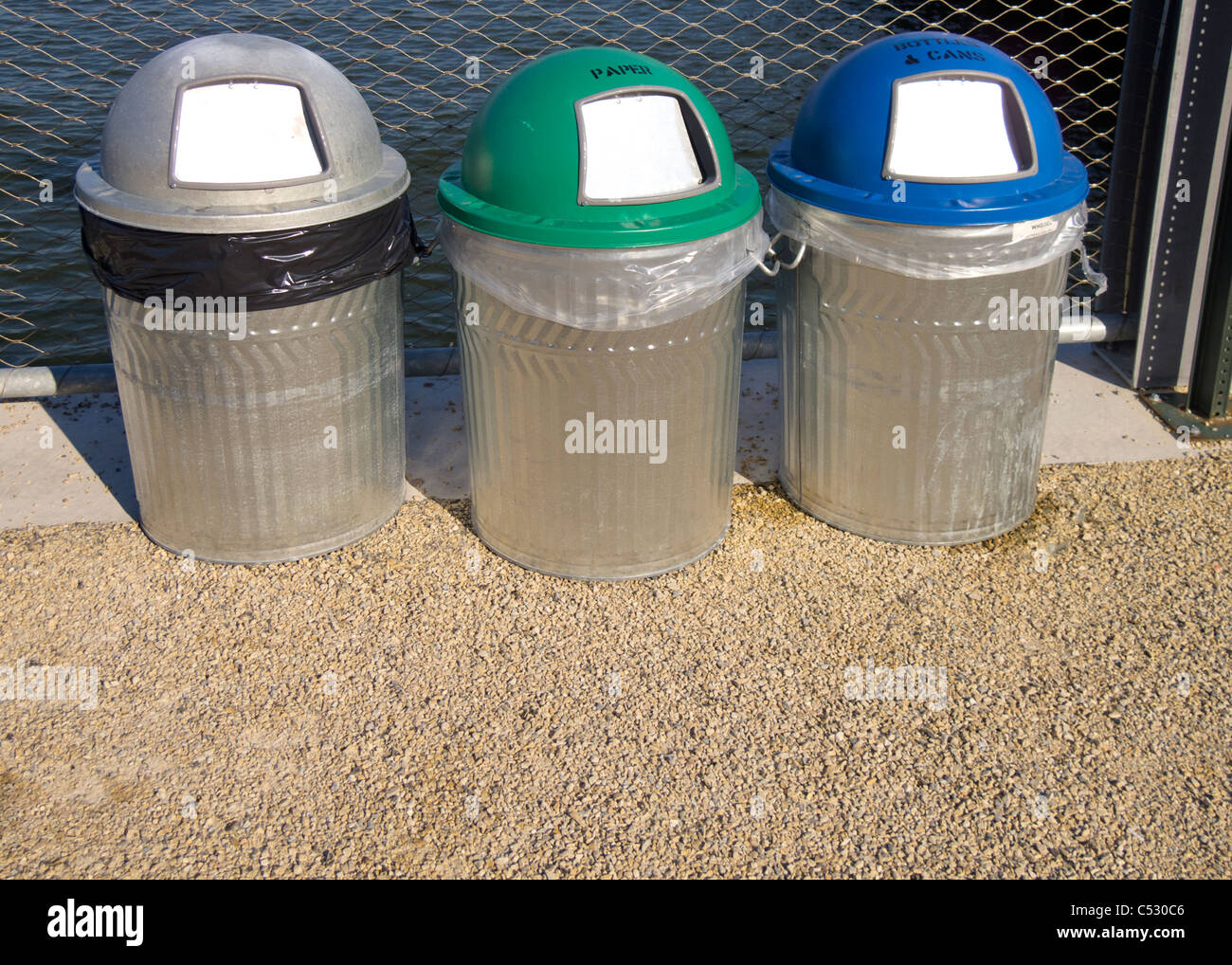 Plastic large trash cans with the lids up and garbage inside against a  brick orange wall. Big green and grey plastic dumpsters on a city street.  Waste Stock Photo - Alamy