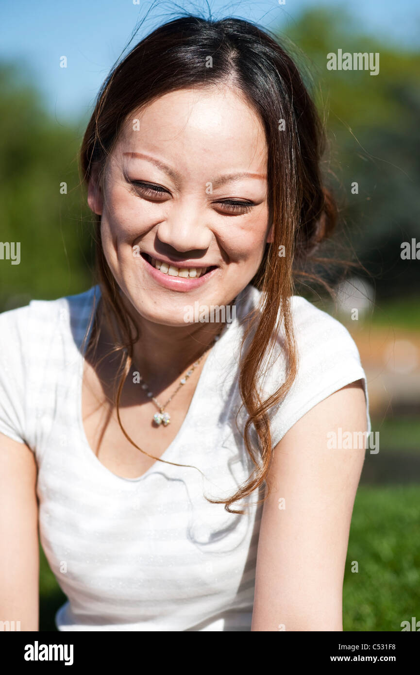 Japanese teen smiling on a grass outdoors Stock Photo