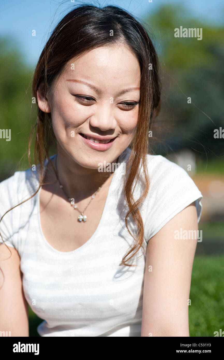Japanese teen smiling on a grass outdoors Stock Photo