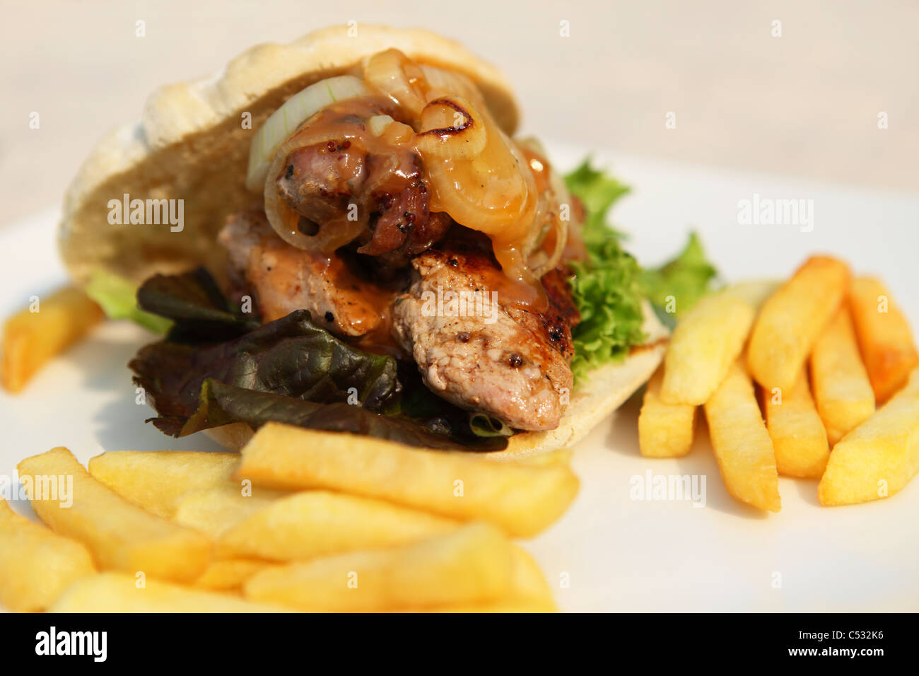A warthog sandwich is served with chips in the town of Victoria Falls, Zimbabwe. Stock Photo