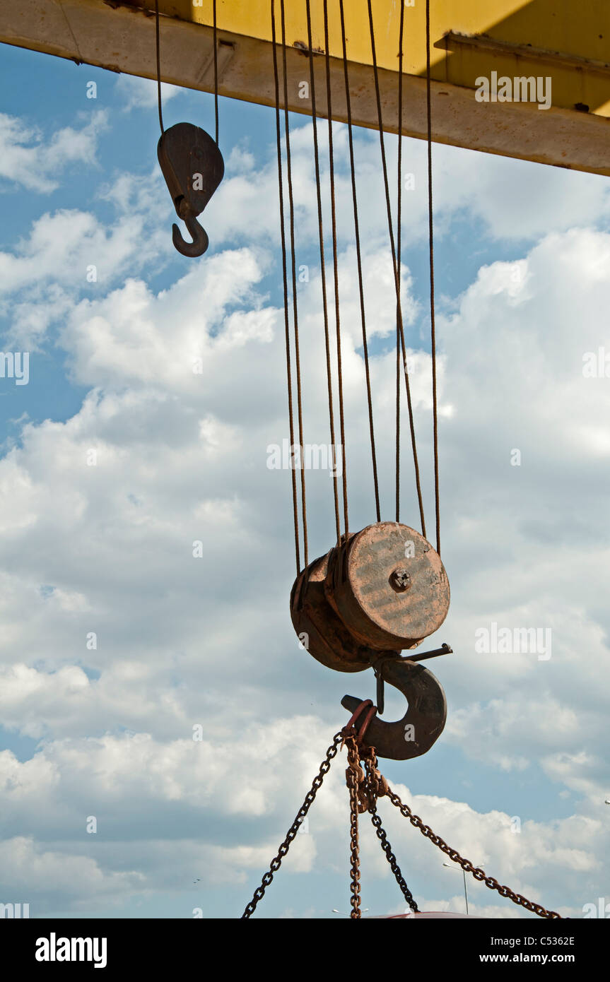 Two lifting hooks on an old railroad crane with chains.Blue sky Stock
