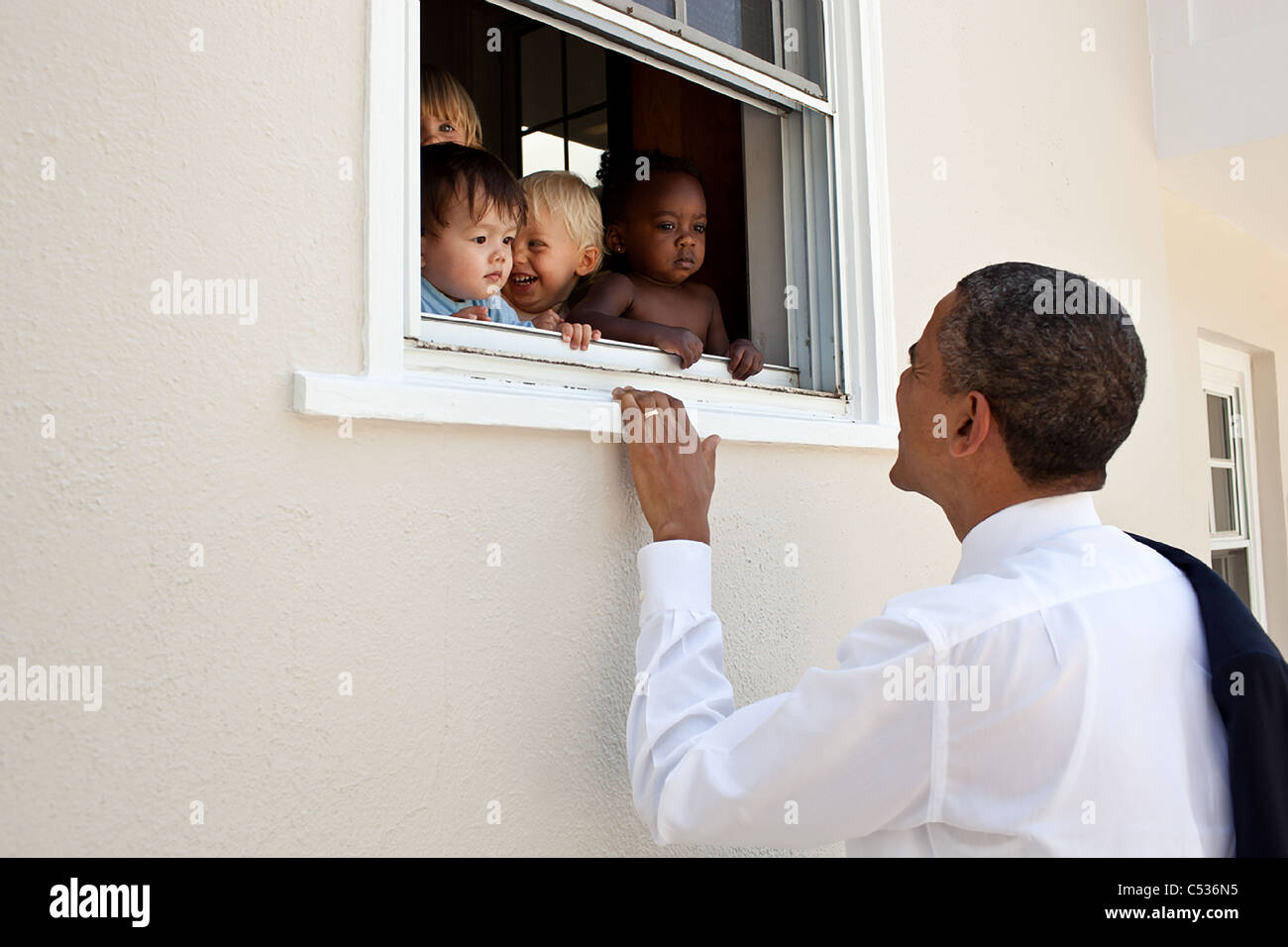 President Barack Obama greets children at a day care facility adjacent to daughter Sasha's school in Bethesda, Md Stock Photo