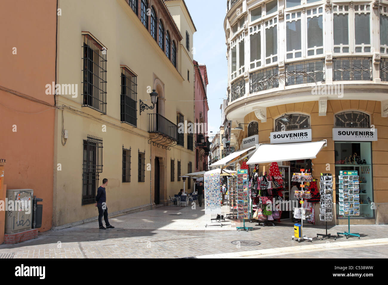 Malaga Spain narrow pedestrian street between houses, apartments and businesses. Souvenir signs on corner. Stock Photo