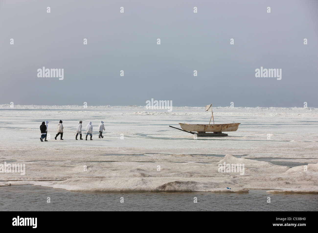 Whaling crew gets ready to bring their Umiaq off the Chuchki Sea ice at the end of the spring whaling season in Barrow, Alaska Stock Photo
