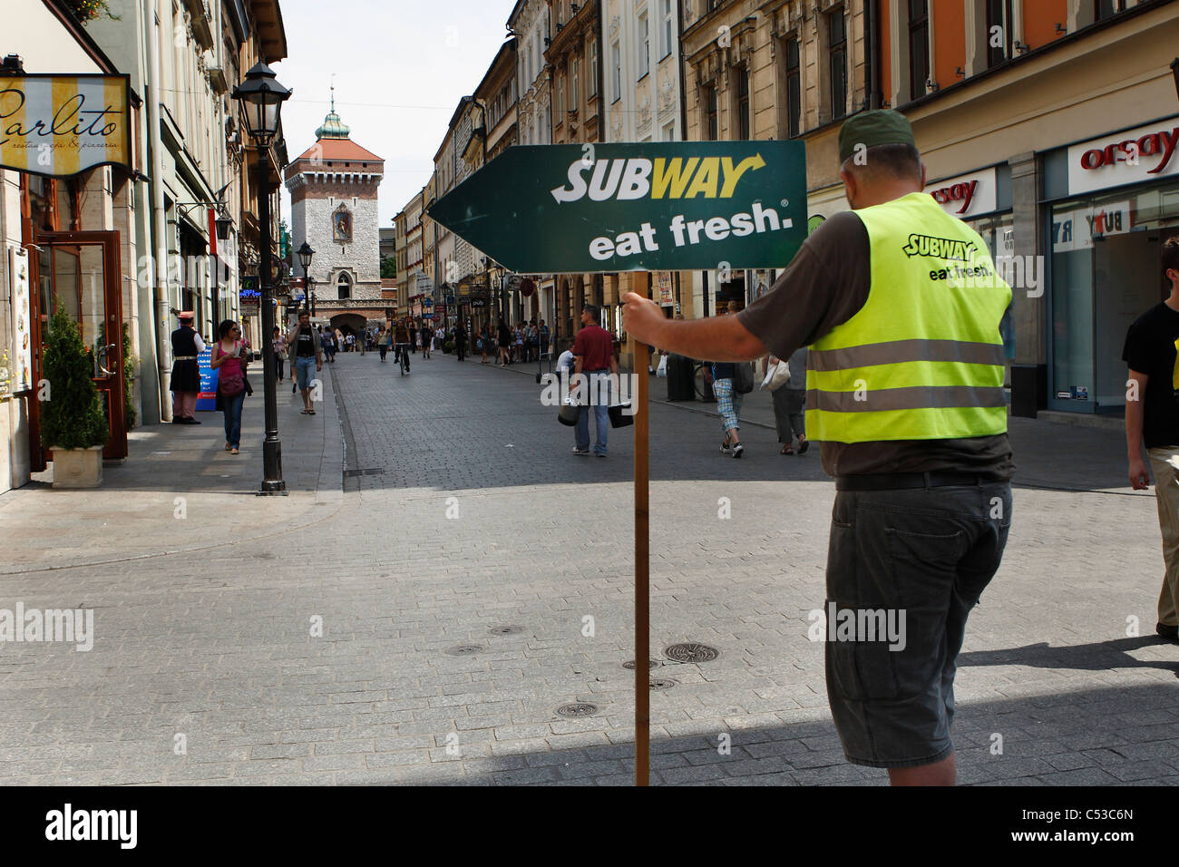 A man at Florianska Street with arrow pointing Subway bar. Krakow, Poland. Stock Photo