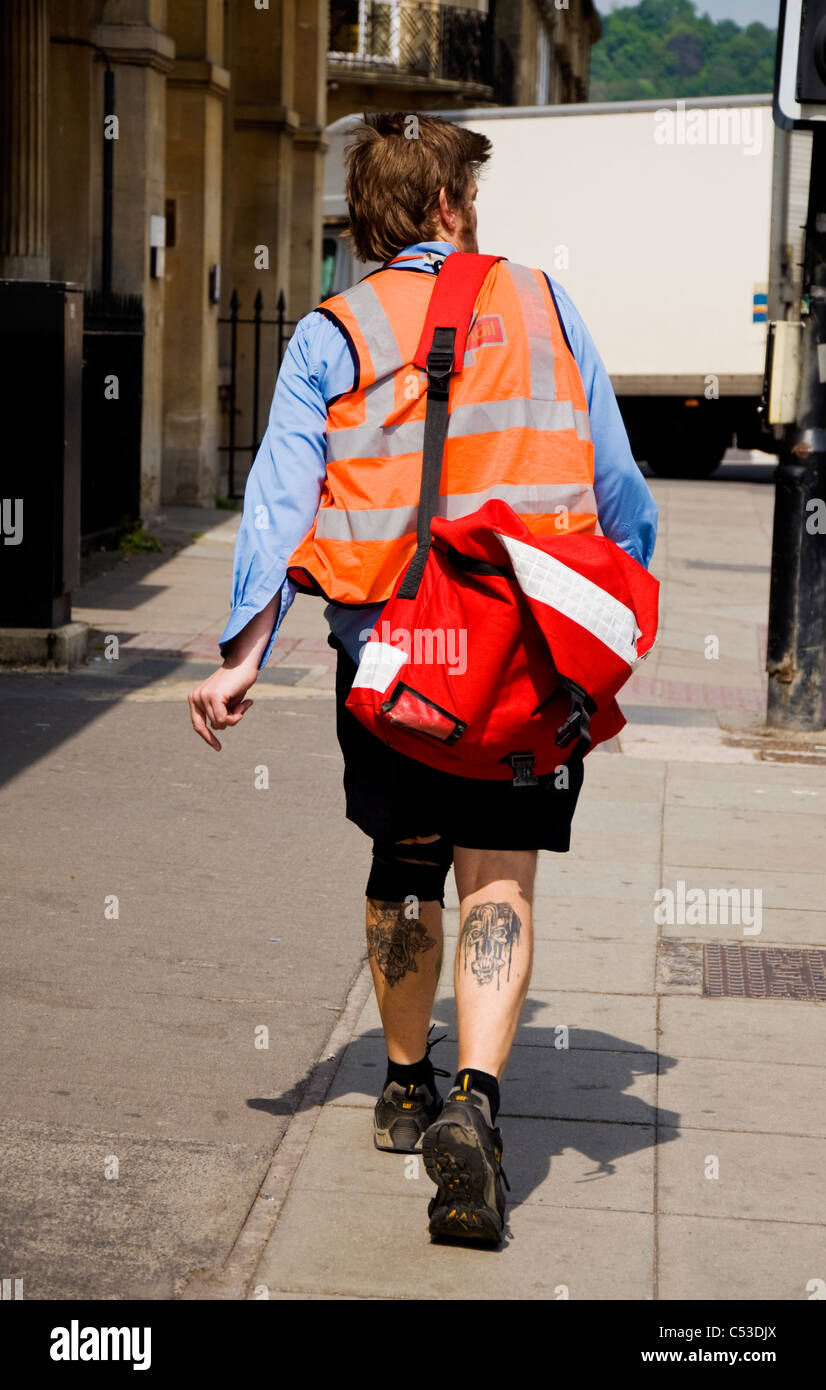 Postman wearing shorts with tattooed legs in summer Stock Photo - Alamy