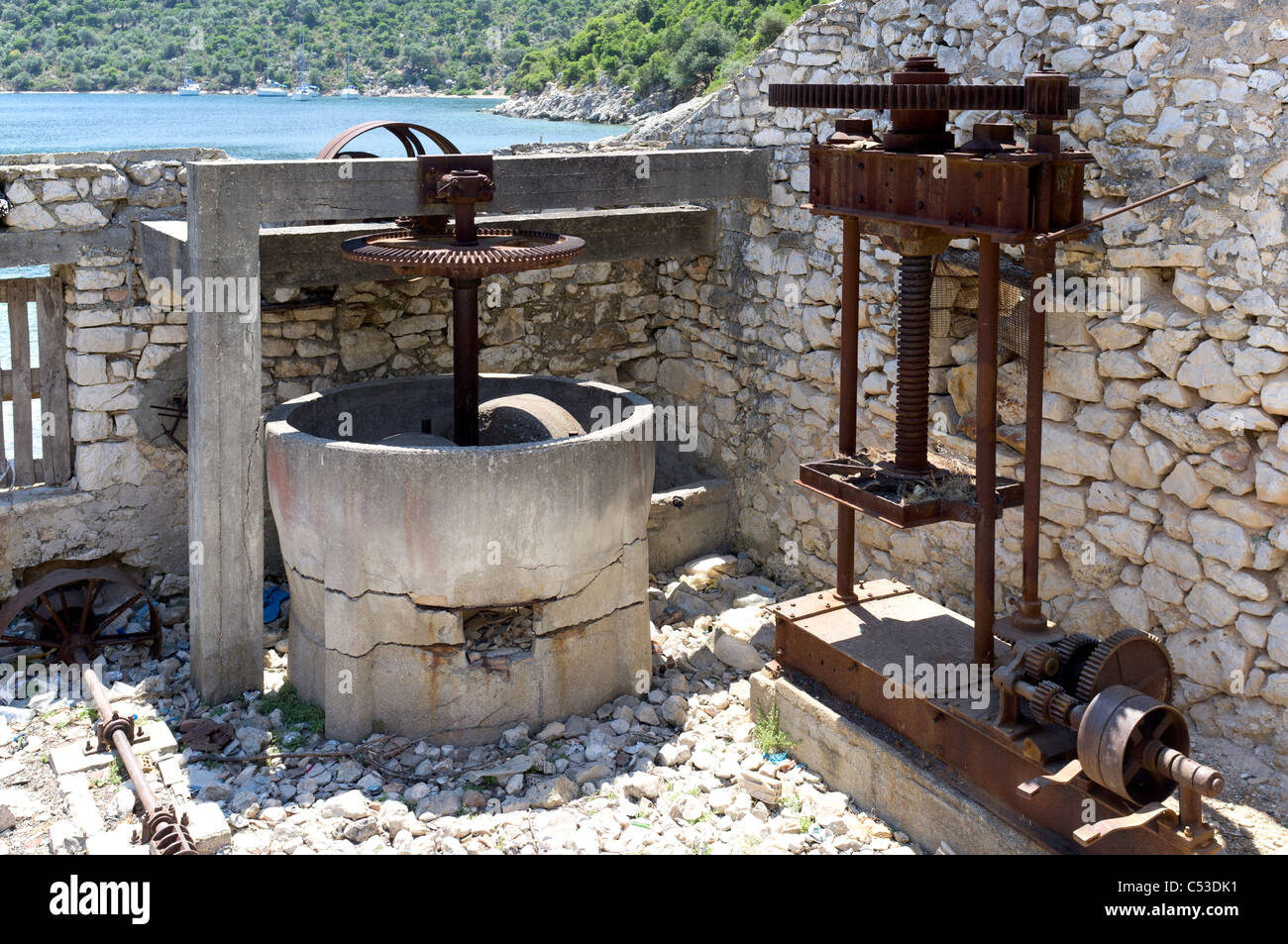 Rusting olive press and mill, Port Leone, Kalamos, Ionian, Greece. Stock Photo