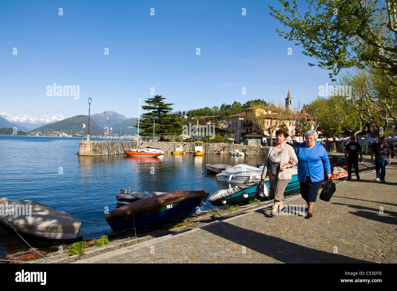 Senior women walk on quayside in Laveno Mombello on lake Maggiore Lombardy Italy Stock Photo