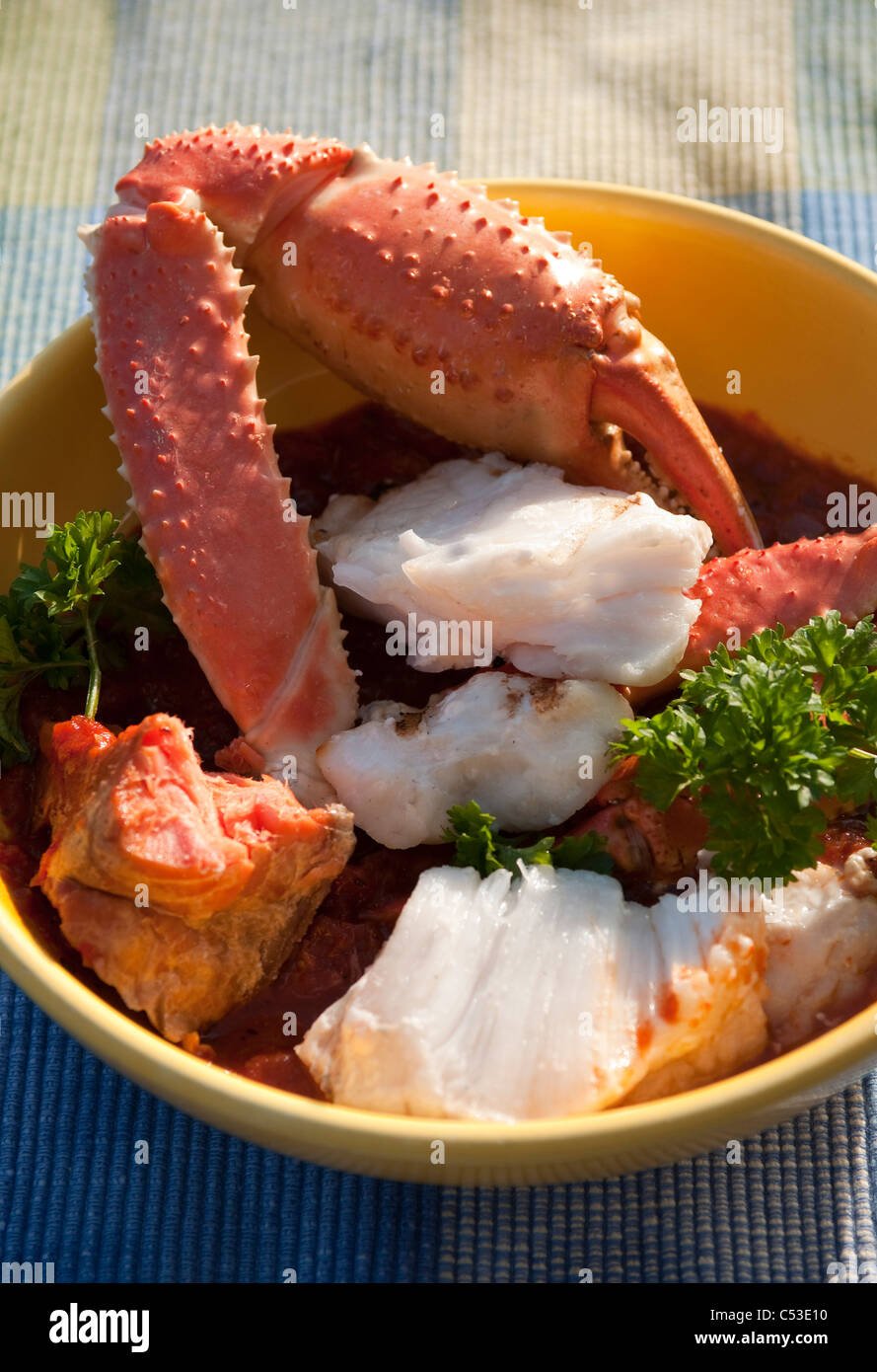 Close up view of Cioppino fish stew containing fresh Alaskan Tanner Crab, Smoked King Salmon, Halibut, and Rockfish, Alaska Stock Photo