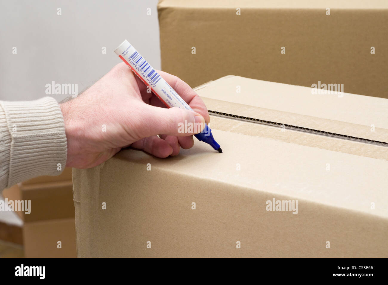 man's hand labeling cardboard box with felt pen Stock Photo
