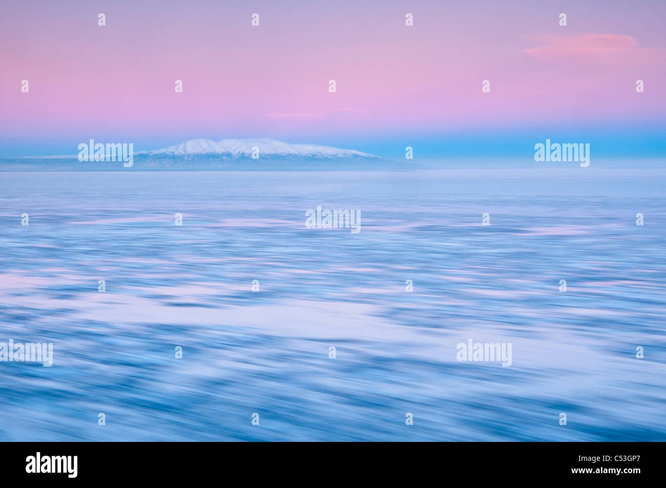 Blurred motion view of outgoing tide and ice at sunrise with Mt. Susitna in the background, Point Woronzof, Anchorage, Alaska Stock Photo