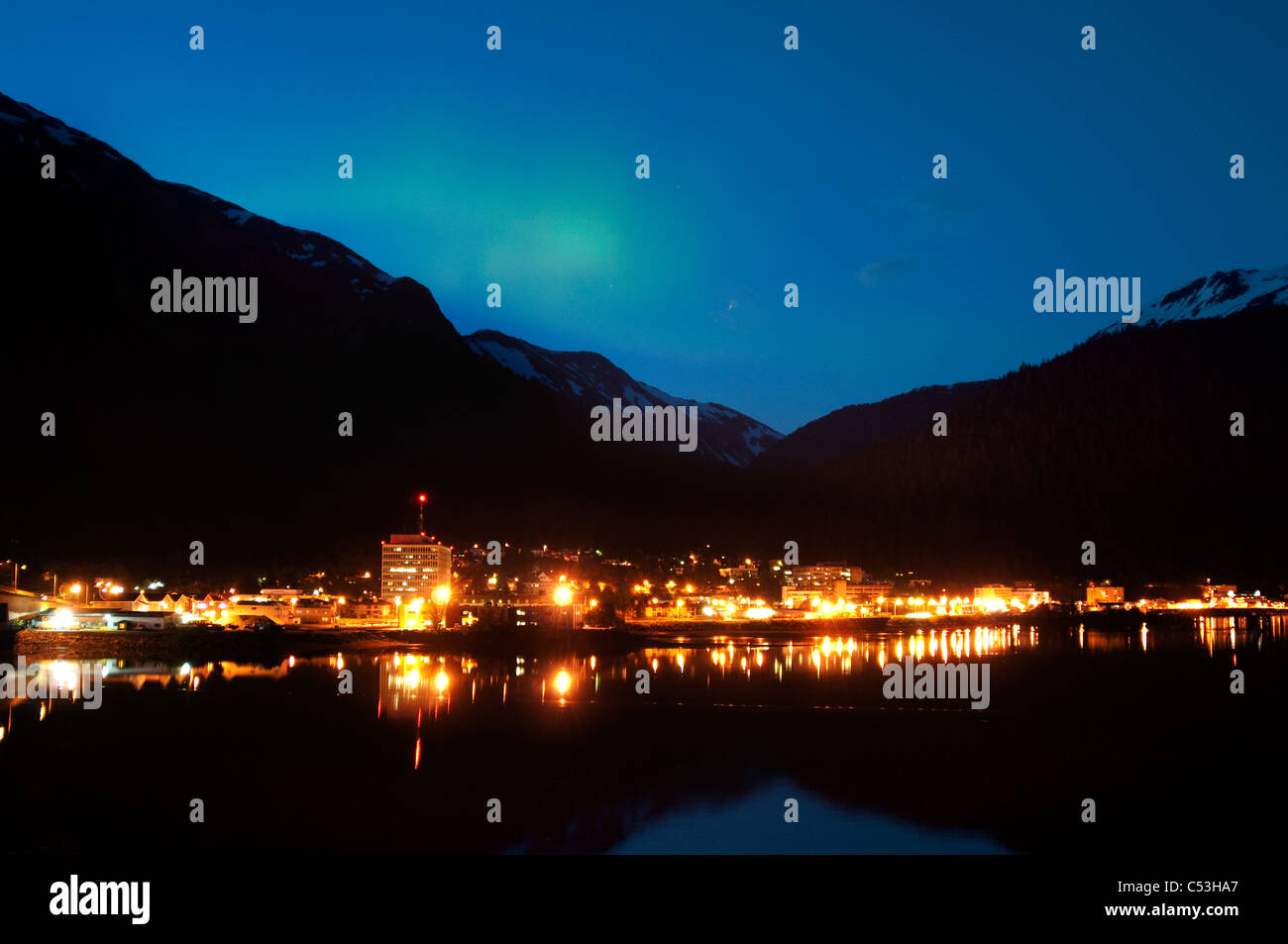 Nighttime view of downtown Juneau with a faint, green aurora borealis display in early Summer, Southeast Alaska Stock Photo