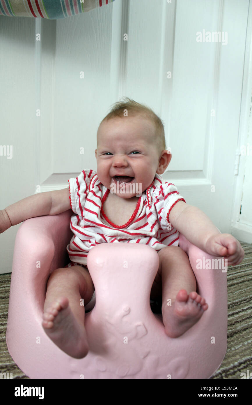 Three Month Old Baby Girl Smiling In Bumbo Seat Stock Photo