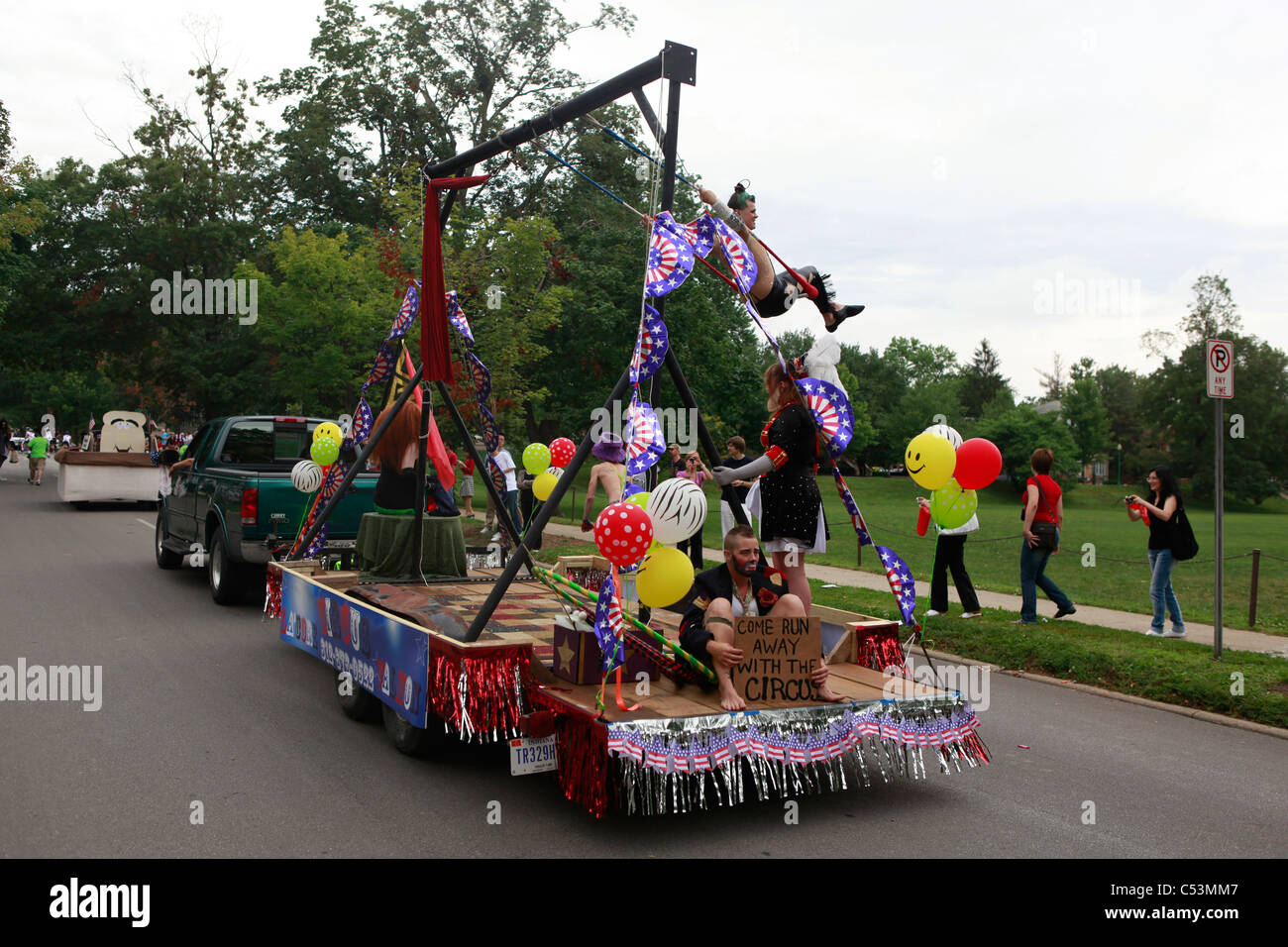 Woman swinging on La'Core Valmon circus float 4th of July Parade --- Bloomington  Stock Photo