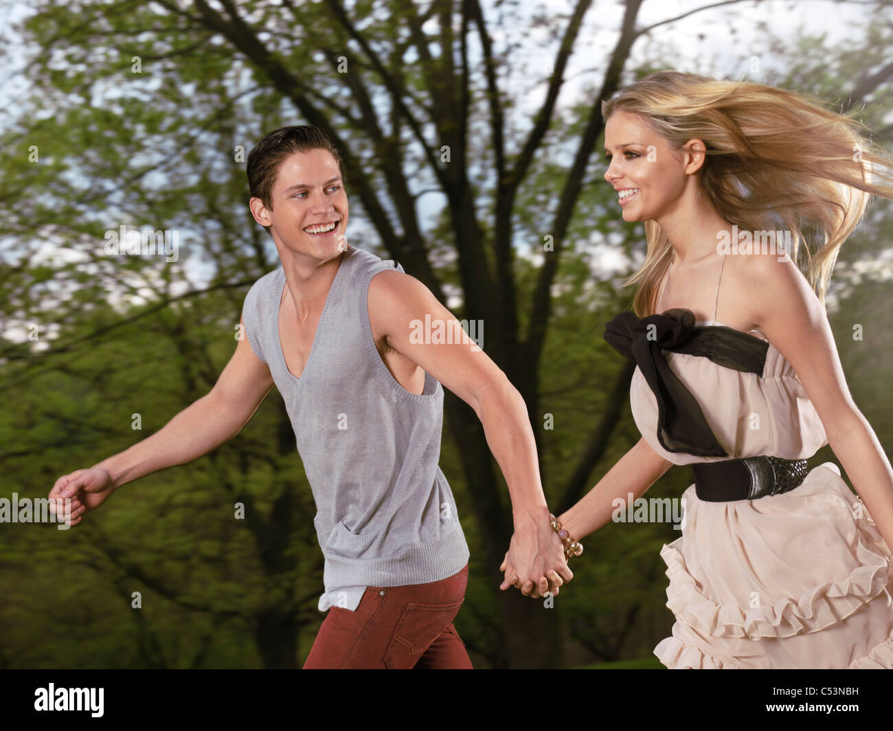 License available at MaximImages.com - Young happy romantic couple running together holding their hands Stock Photo
