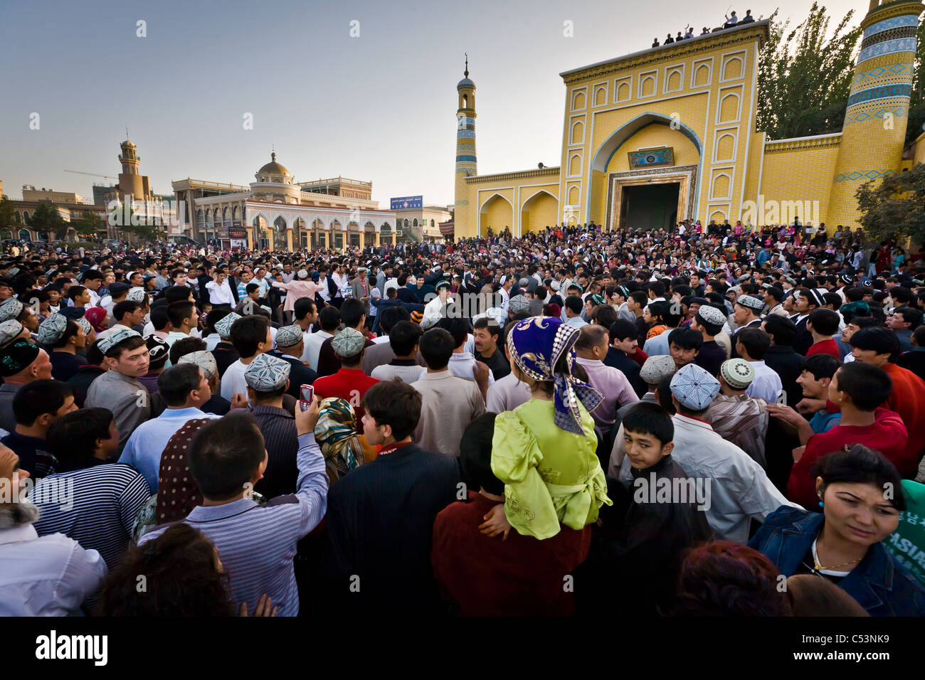 Crowd watches Uyghur men dance outside Id Kah Mosque after service at the end of Ramadan. Kashgar, Xinjiang province, Ch Stock Photo