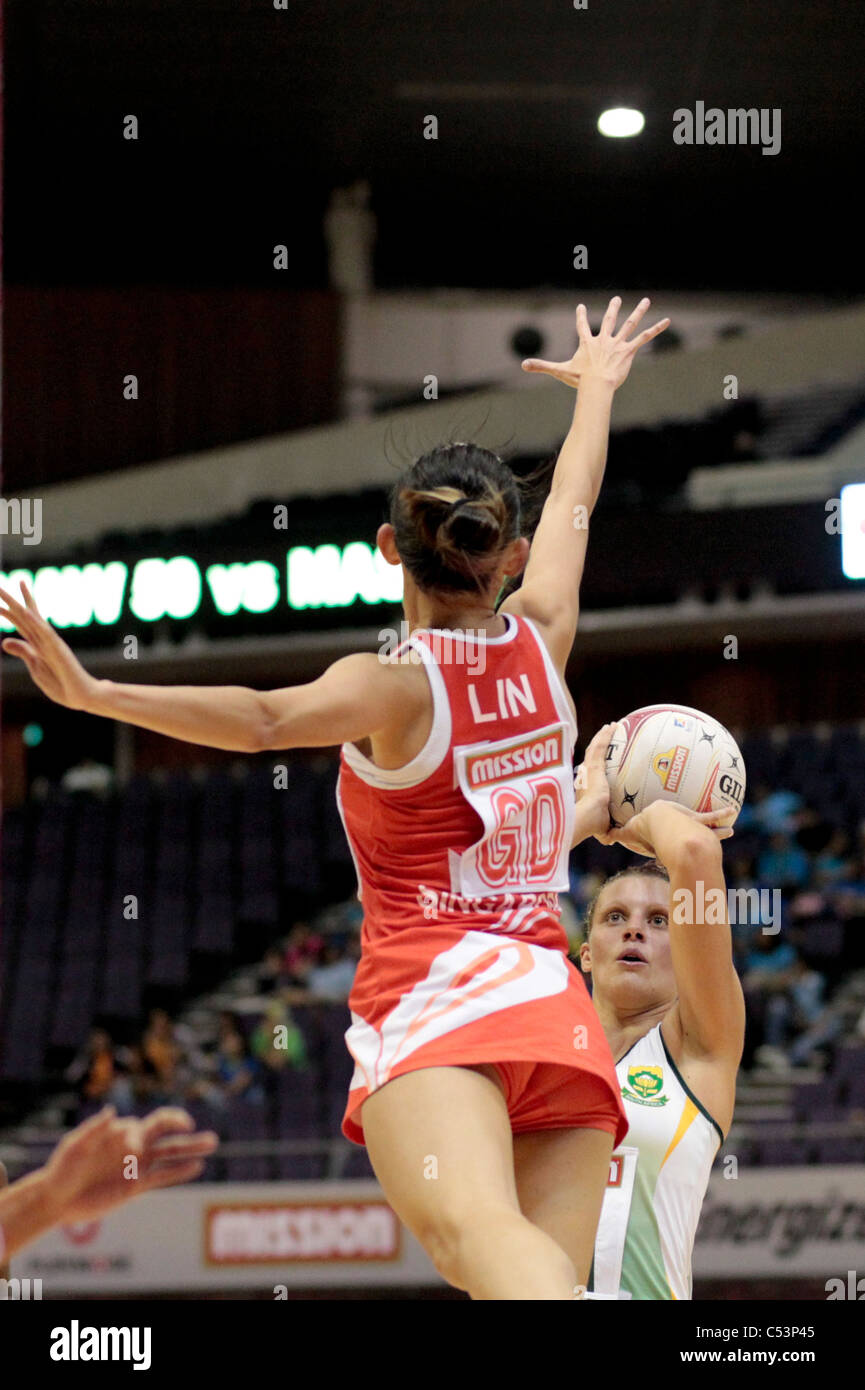05.07.2011 Lin Qingyi of Singapore(left) attempts to block Maryka Holtzhausen during the Pool C match between Singapore and South Africa, Mission Foods World Netball Championships 2011 from the Singapore Indoor Stadium in Singapore. Stock Photo