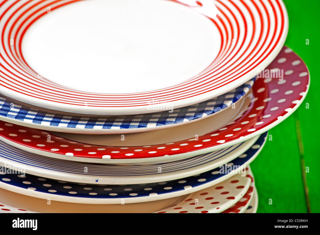 rustic and colorful plates on a green wooden table Stock Photo