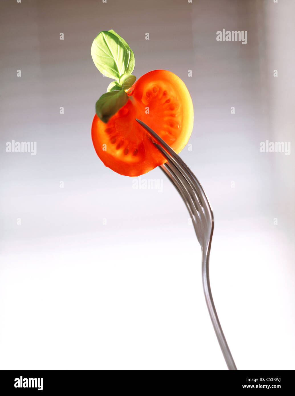 Still: Slice of tomato with basil on fork Stock Photo - Alamy