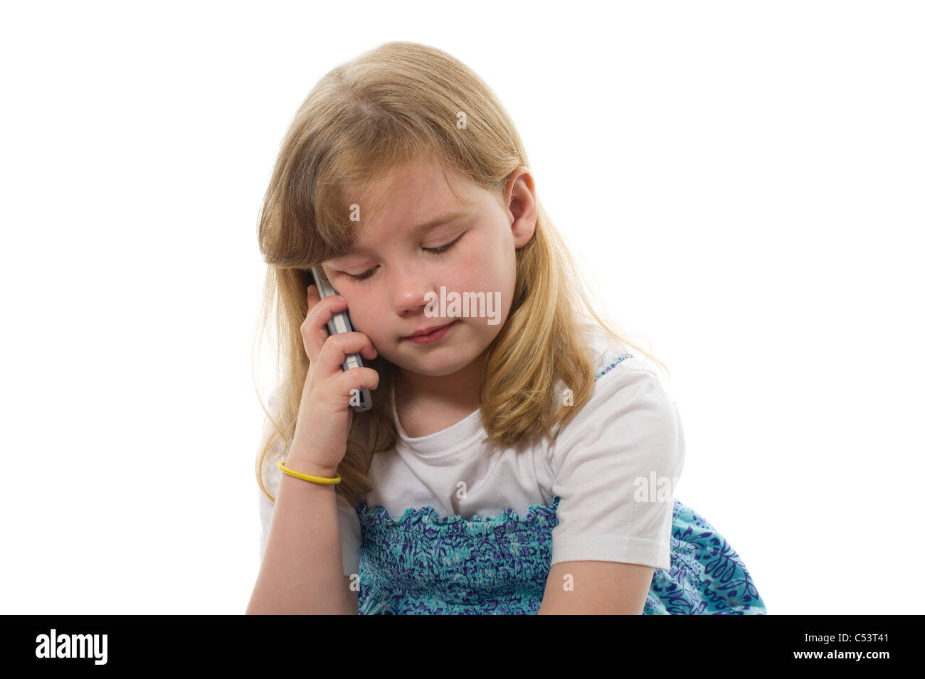 Image of young girl using a mobile phone photographed against a plain white background. Stock Photo