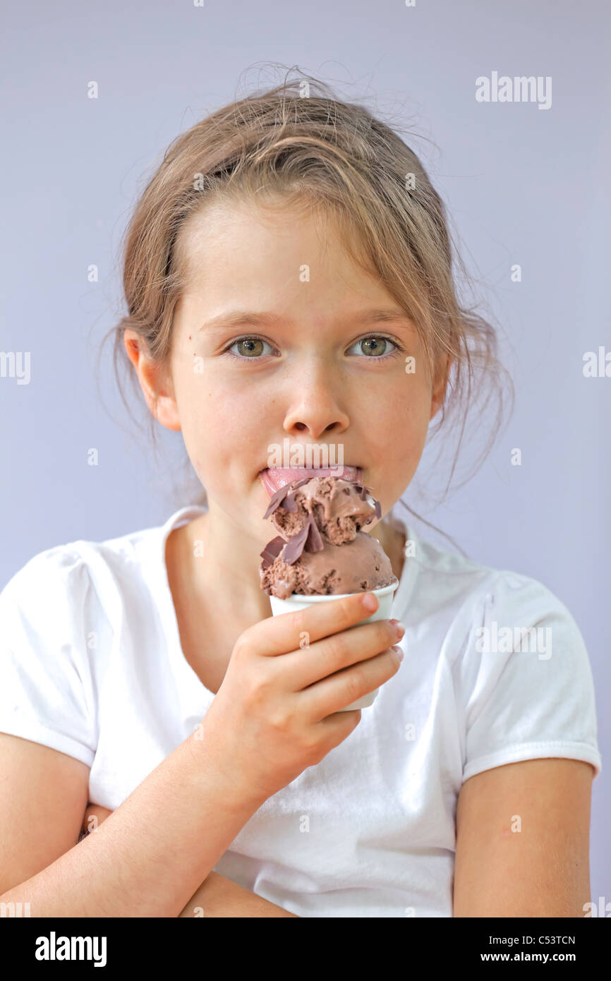 seven year old girl who is eating a chocolate ice cream Stock Photo