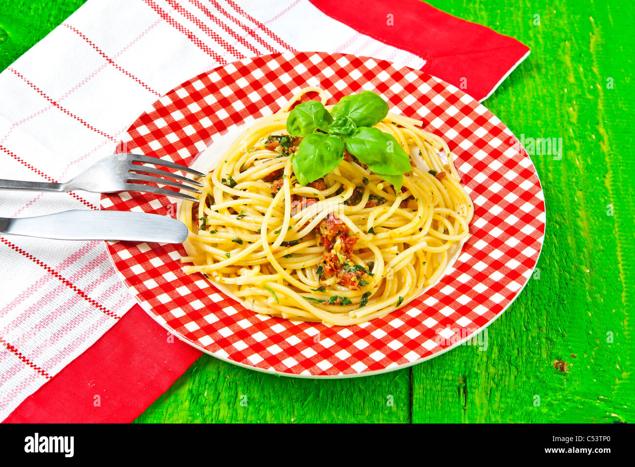 Spaghetti with pesto, made from dried tomatoes, Grana, pecorino, arugula, basil, pine nuts and garlic Stock Photo