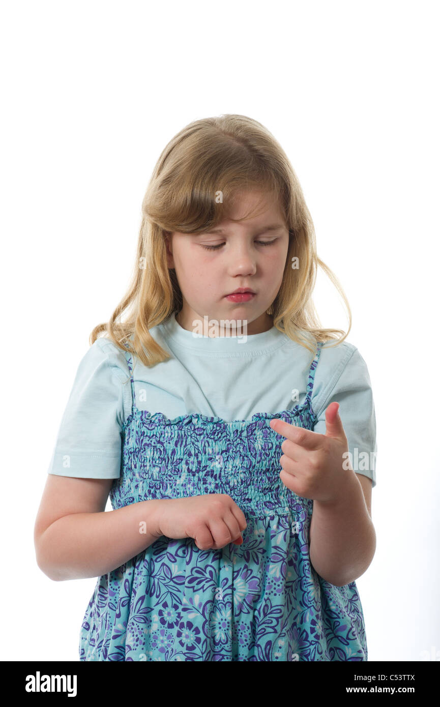 A young primary age girl doing addition by counting on her fingers photographed against a white studio background. Stock Photo