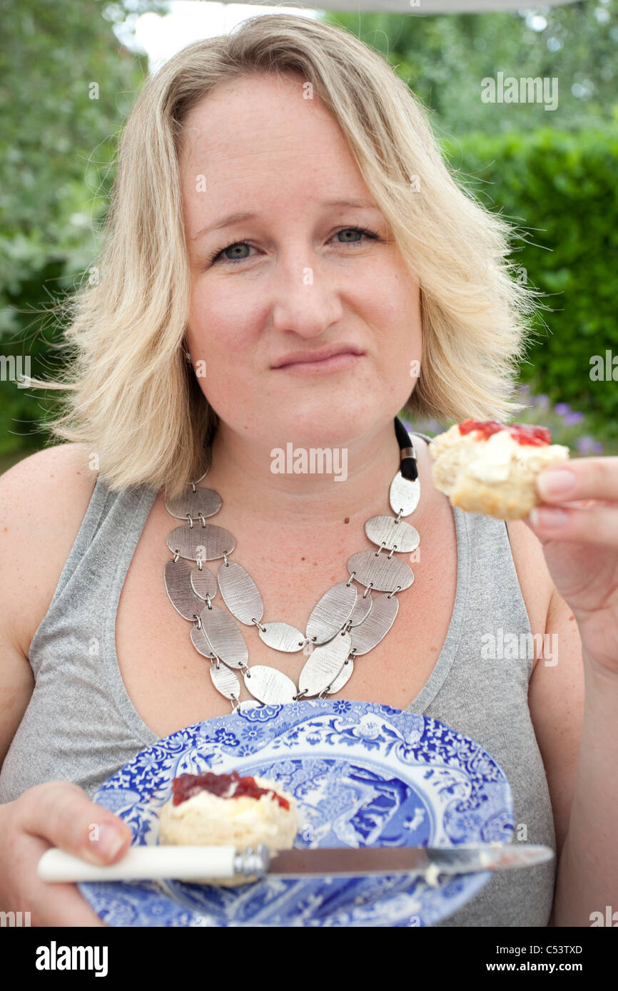 unhappy female adult with strawberry and cream scones Stock Photo
