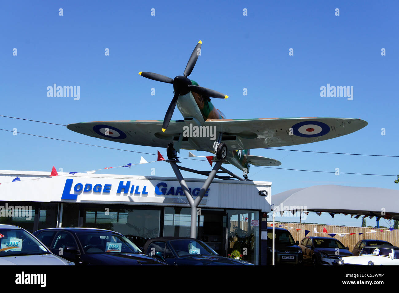 Spitfire aeroplane on top of car sales garage Stock Photo Alamy
