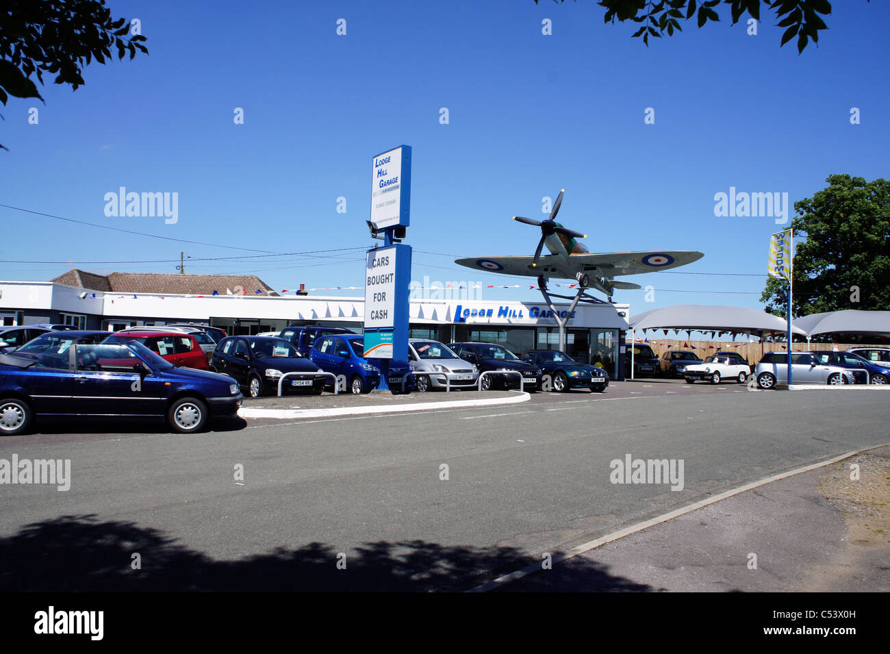 Spitfire aeroplane on top of car sales garage Stock Photo Alamy