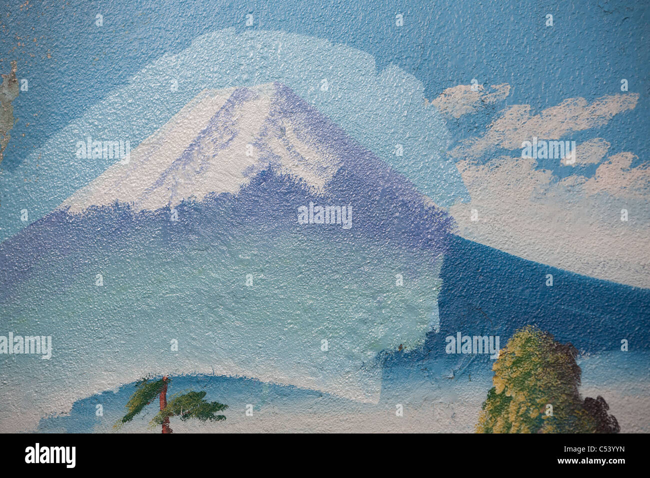 Painting a fresh mural of Mount Fuji over top of older similar view at the 'Moto No Yu' sento (public bath house) in Tokyo. Stock Photo