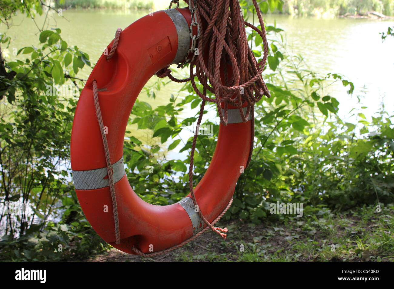 Life-buoy hanging with lake view in the background Stock Photo