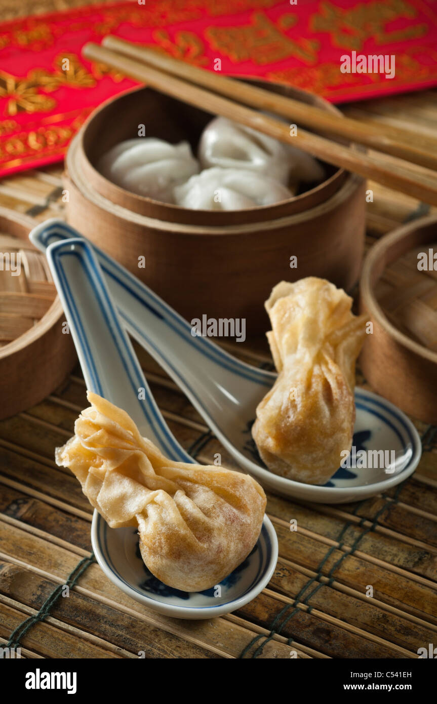 Won ton in Chinese spoons. Steamed dumplings in steamer basket Stock