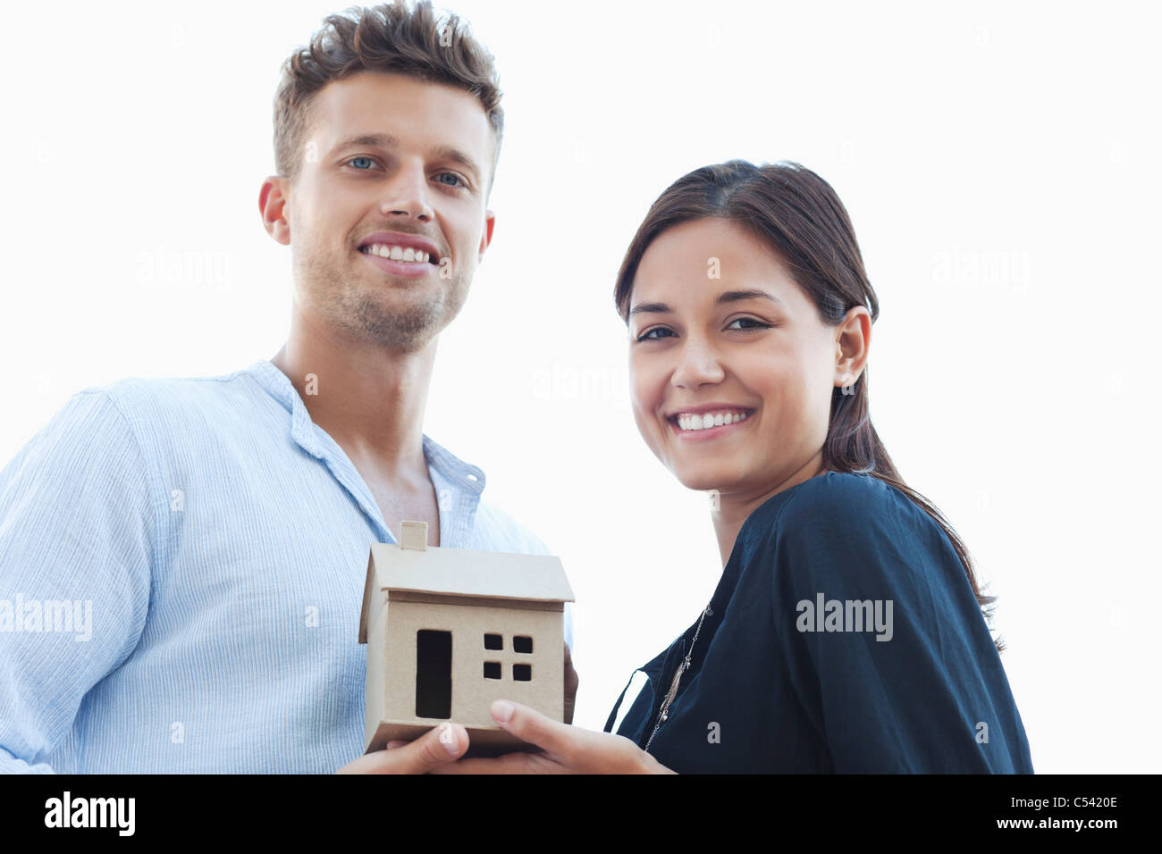 Portrait of a young couple holding a small model house Stock Photo - Alamy