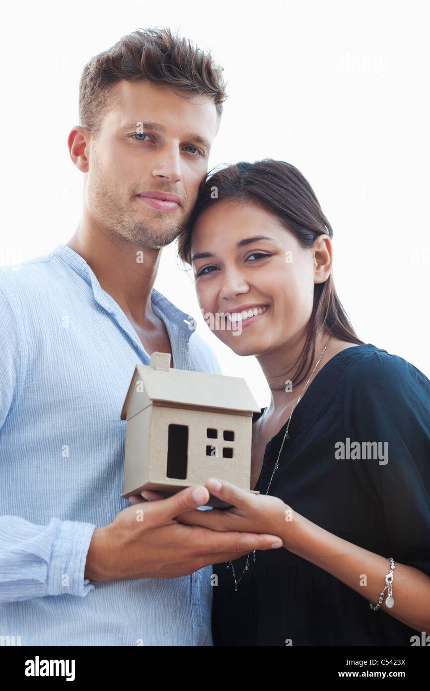 Portrait of a young couple holding small model house Stock Photo - Alamy