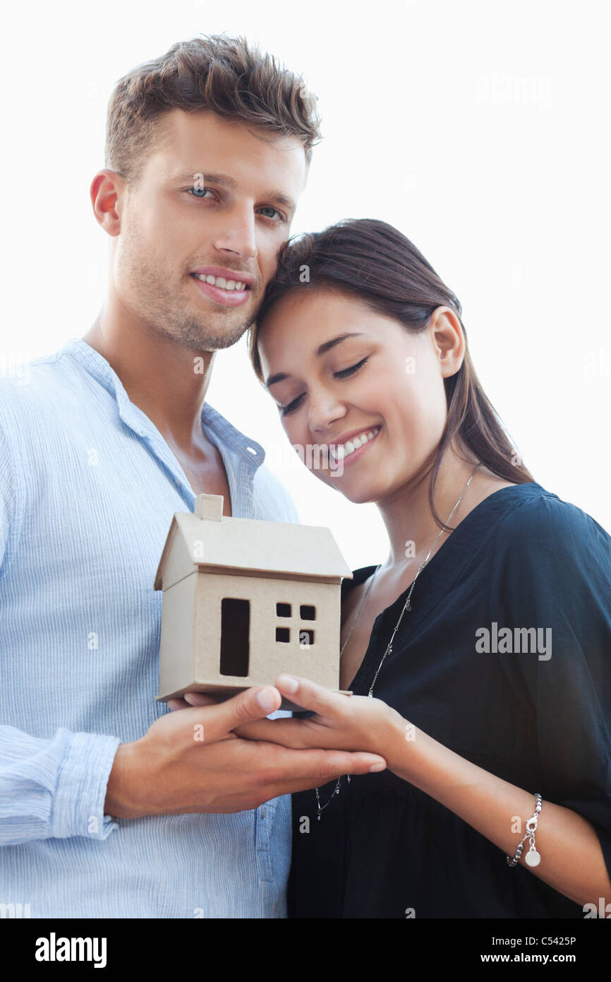 Cute young couple holding small model house Stock Photo - Alamy
