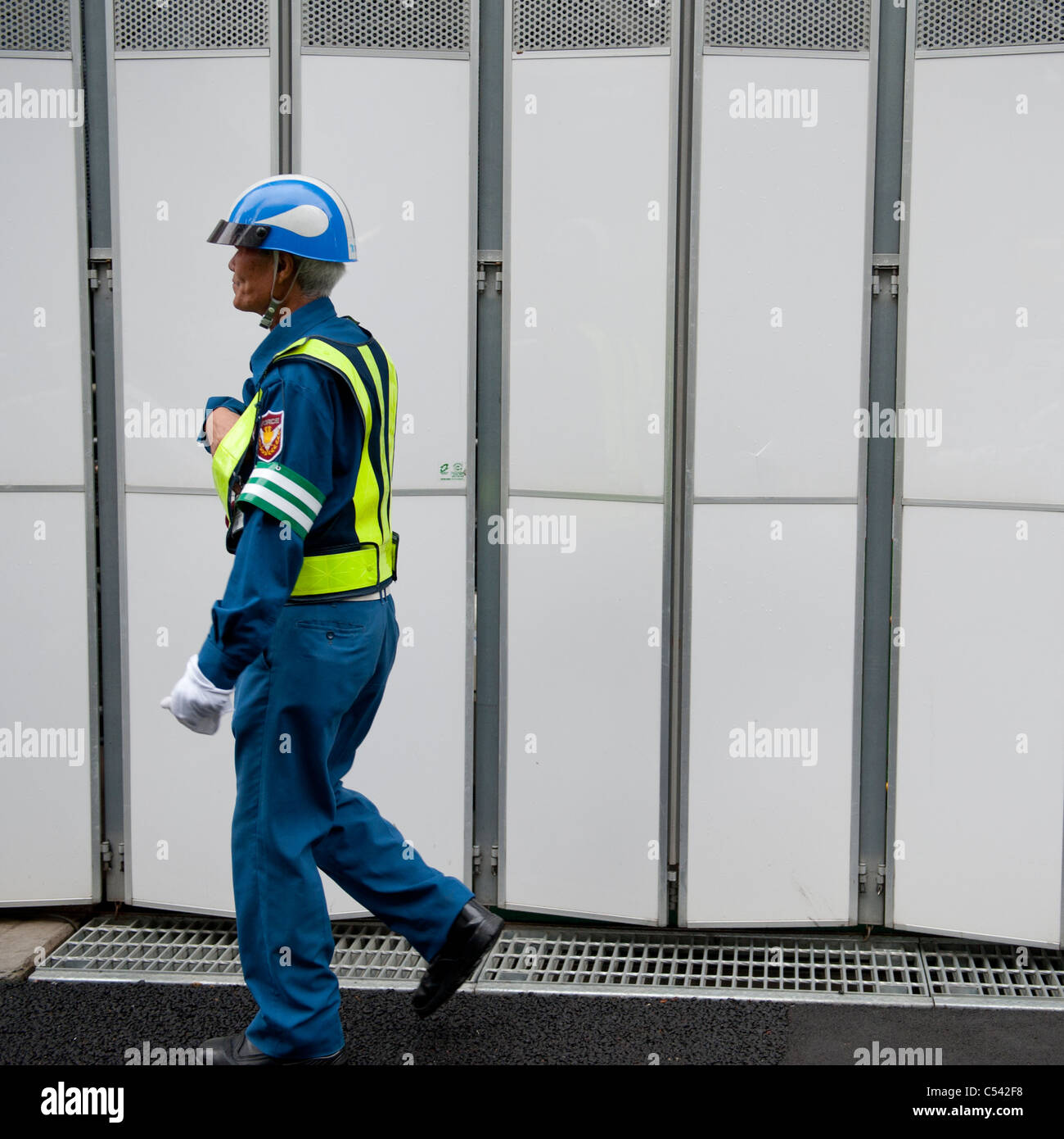 Security guard walking in front of a building hires stock photography