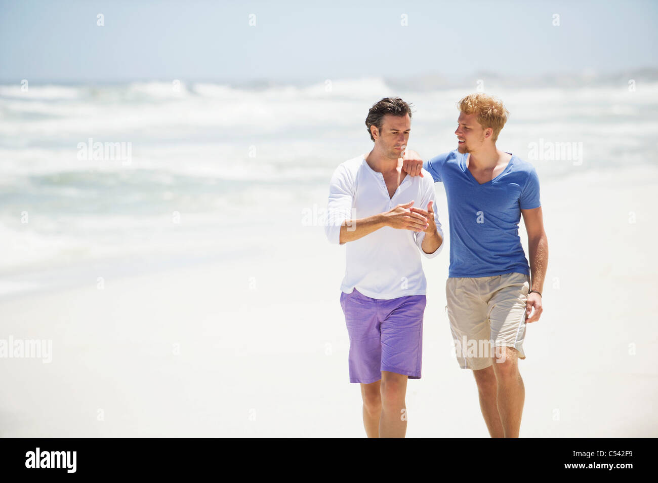 Two men walking on the beach Stock Photo - Alamy