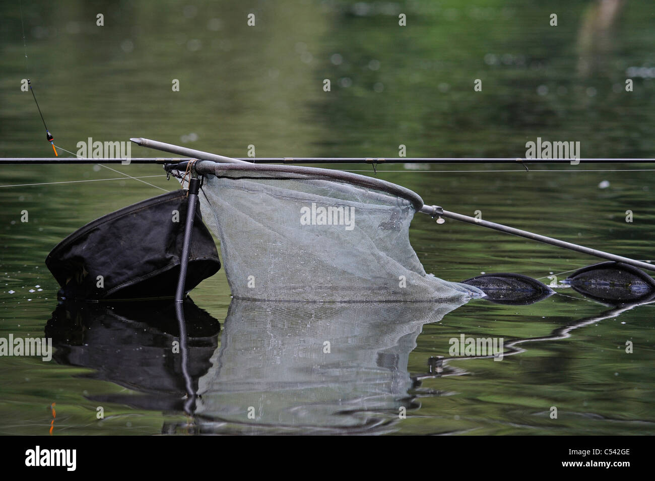 Fresh water fishing equipment fishing net, rod and bait. Stock Photo