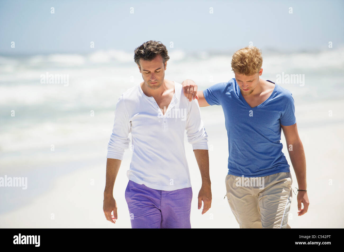 Two men walking on the beach Stock Photo - Alamy