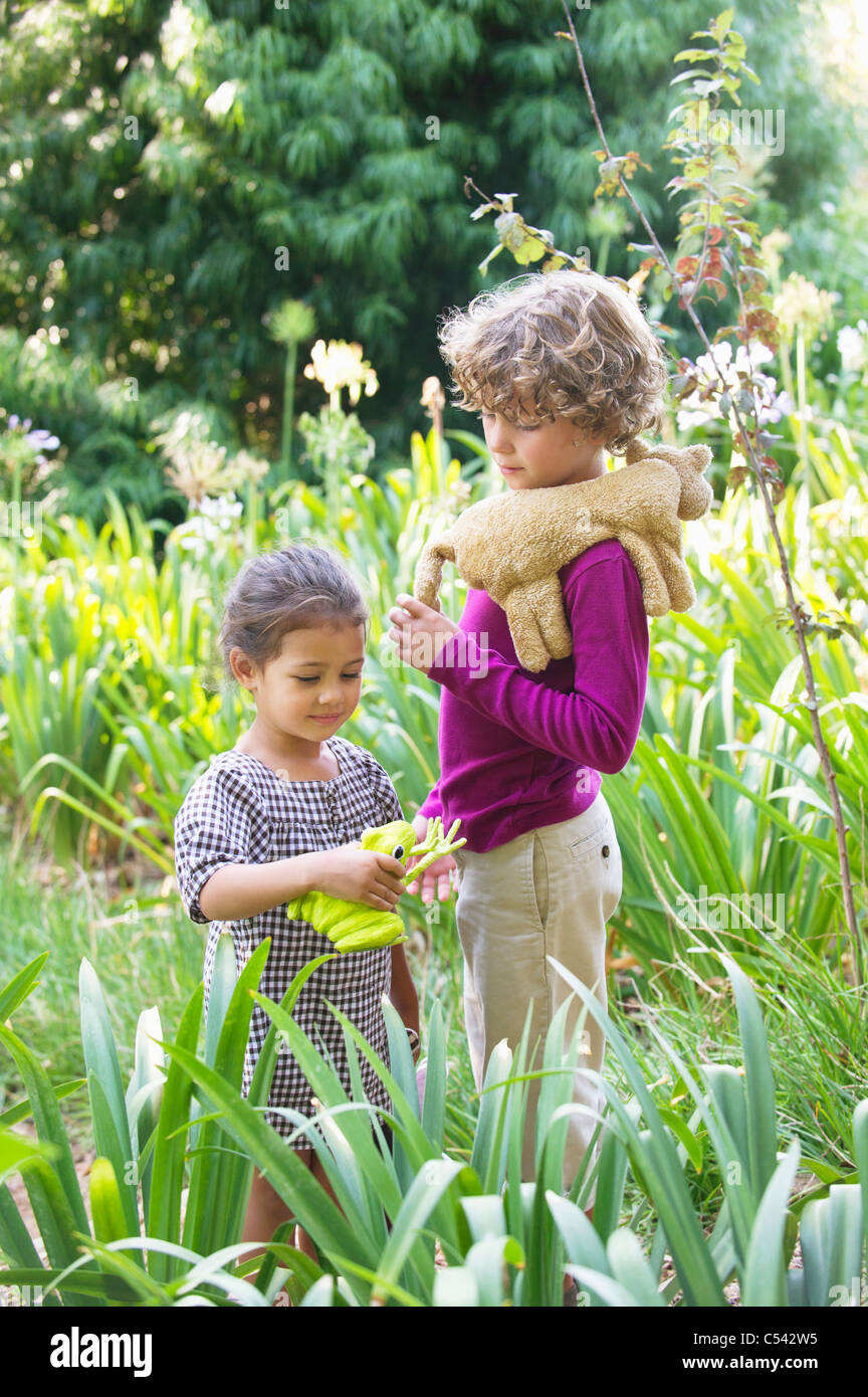 Cute little boy standing with little girl in a garden Stock Photo - Alamy