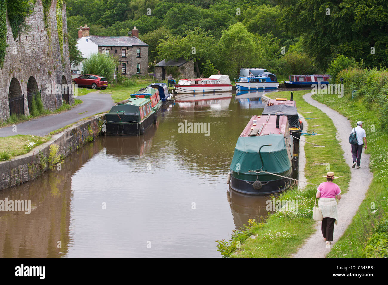 Walkers walking towpath on Monmouthshire and Brecon Canal near village of Llangattock Powys South Wales UK Stock Photo