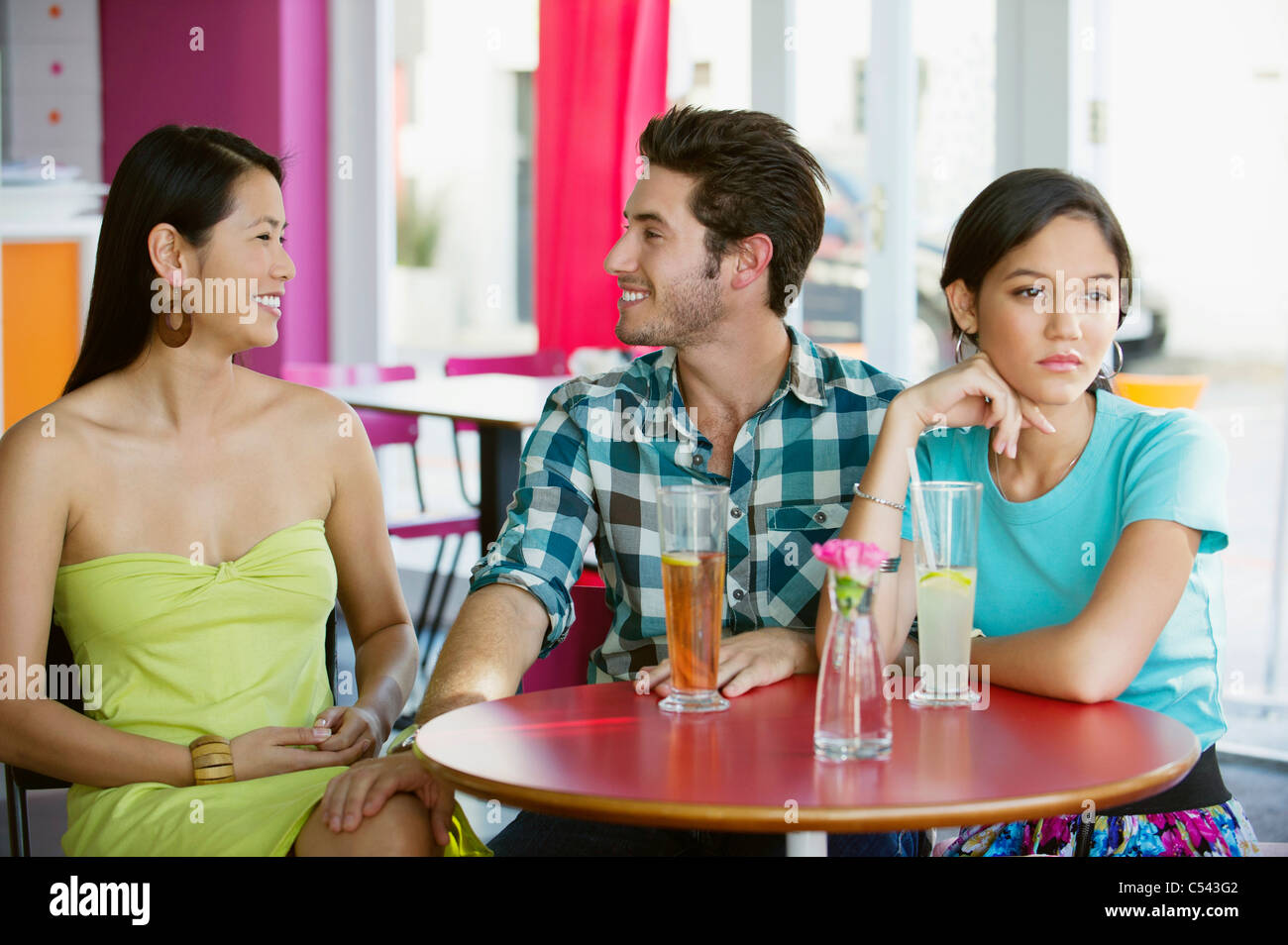 Man talking to a woman while their friend looking away Stock Photo - Alamy