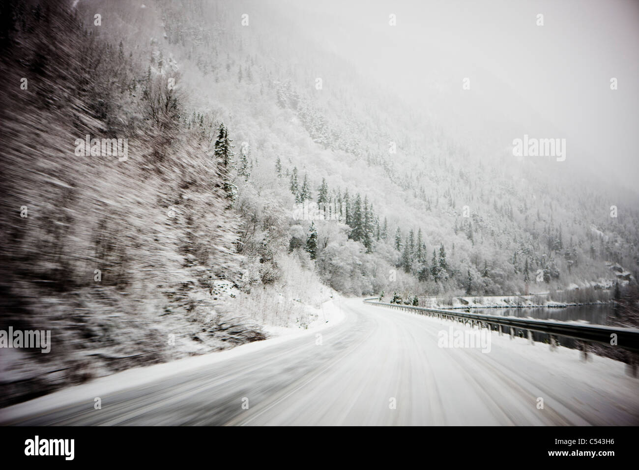 Winter Woodland Mountain Road With Rocky Sides Is Blurred And In The Distant The Snowy Weather Makes It Unclear To See Stock Photo Alamy